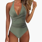 Model wearing halter swimsuit, side profile showing high-cut leg