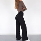 Model sitting in high waisted wide leg trousers
