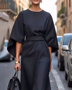 Woman wearing midi dress with belt, three-quarter pose