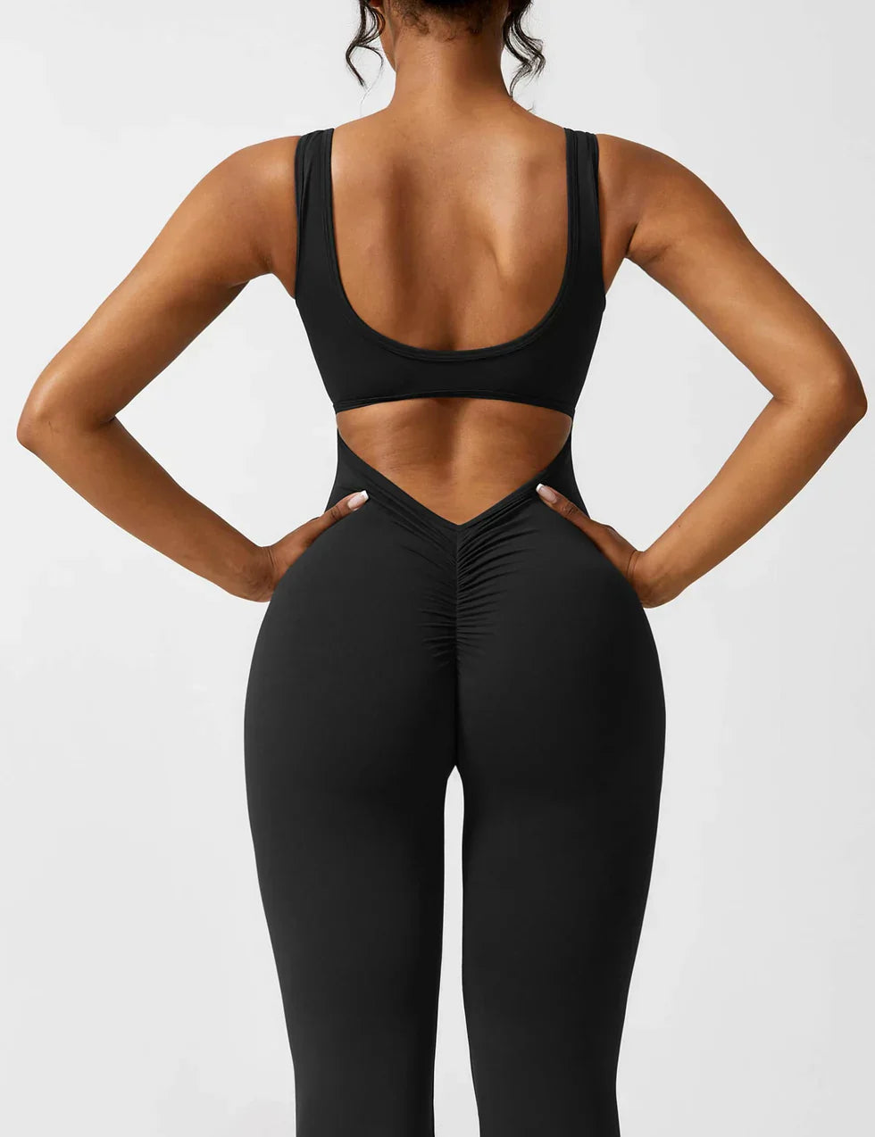 Model wearing sleeveless jumpsuit, full-length standing pose