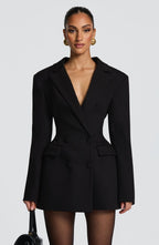 Woman wearing black blazer dress with fitted waist and belt detail