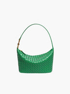 Overhead flat lay of woven leather bag with gold hardware