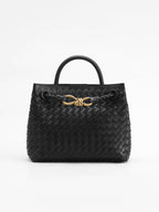 Black woven leather tote bag with gold twist clasp detail, front view