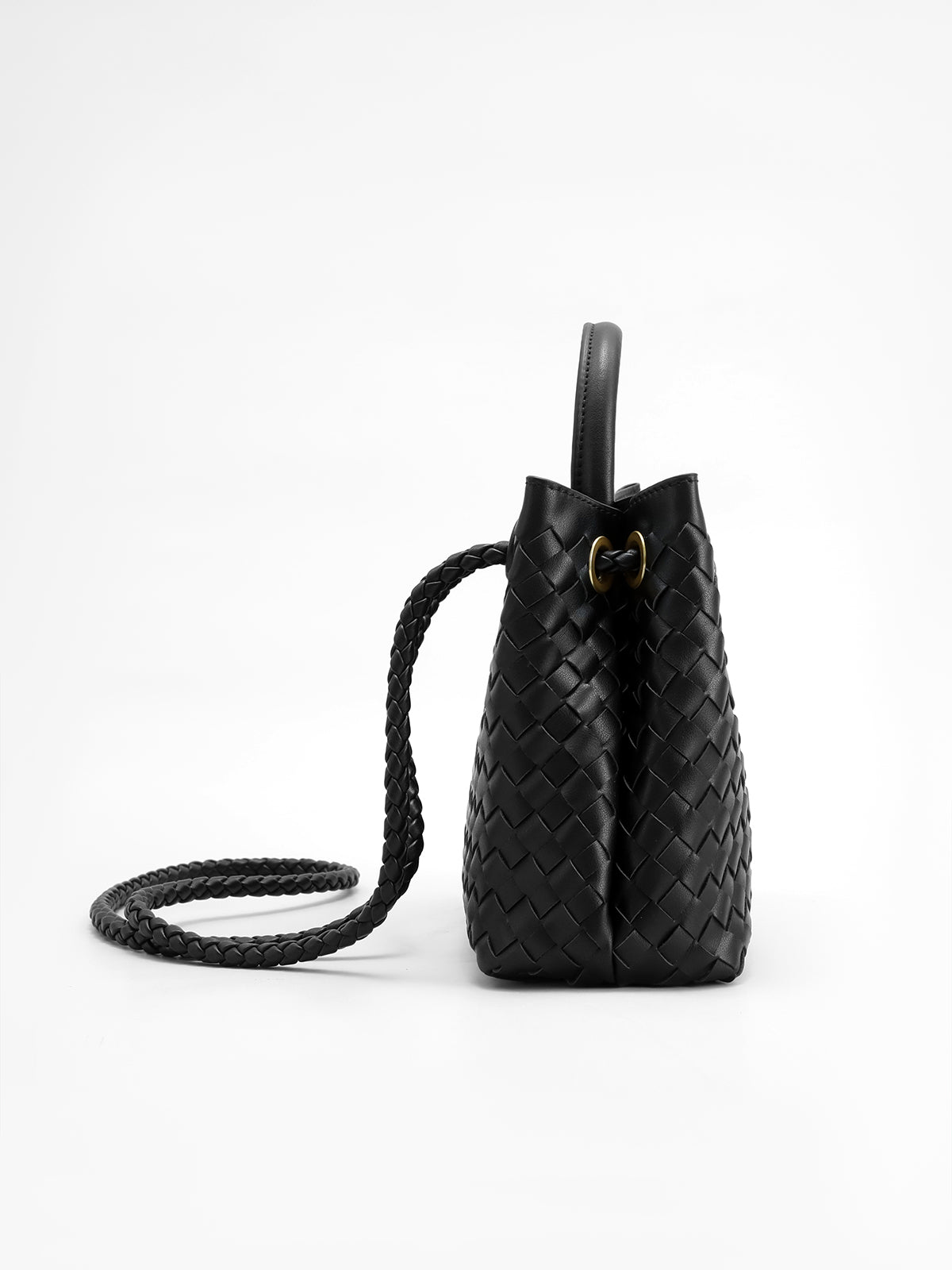Woven tote worn as shoulder bag with twisted gold hardware visible