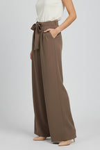 Close-up of drawstring waist and pleating detail on palazzo trousers