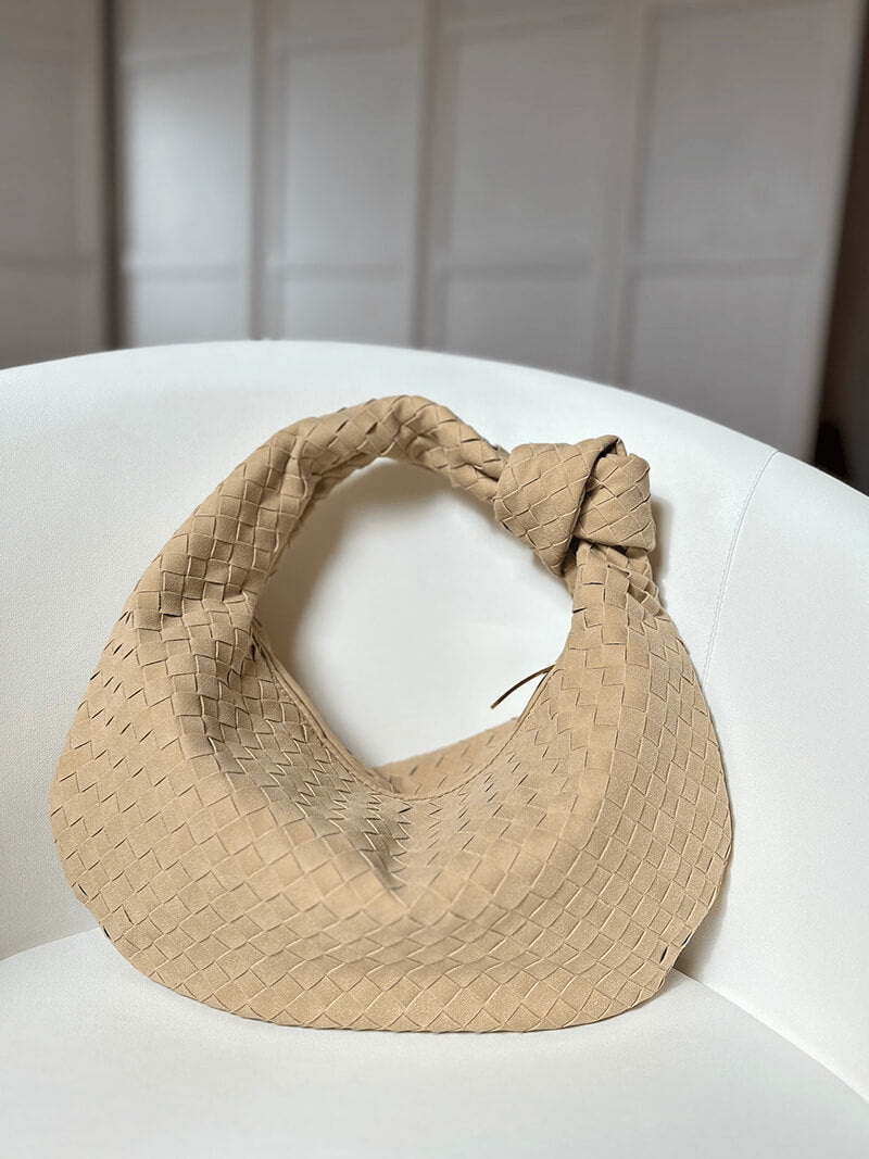 Woman holding woven bag at waist, front view