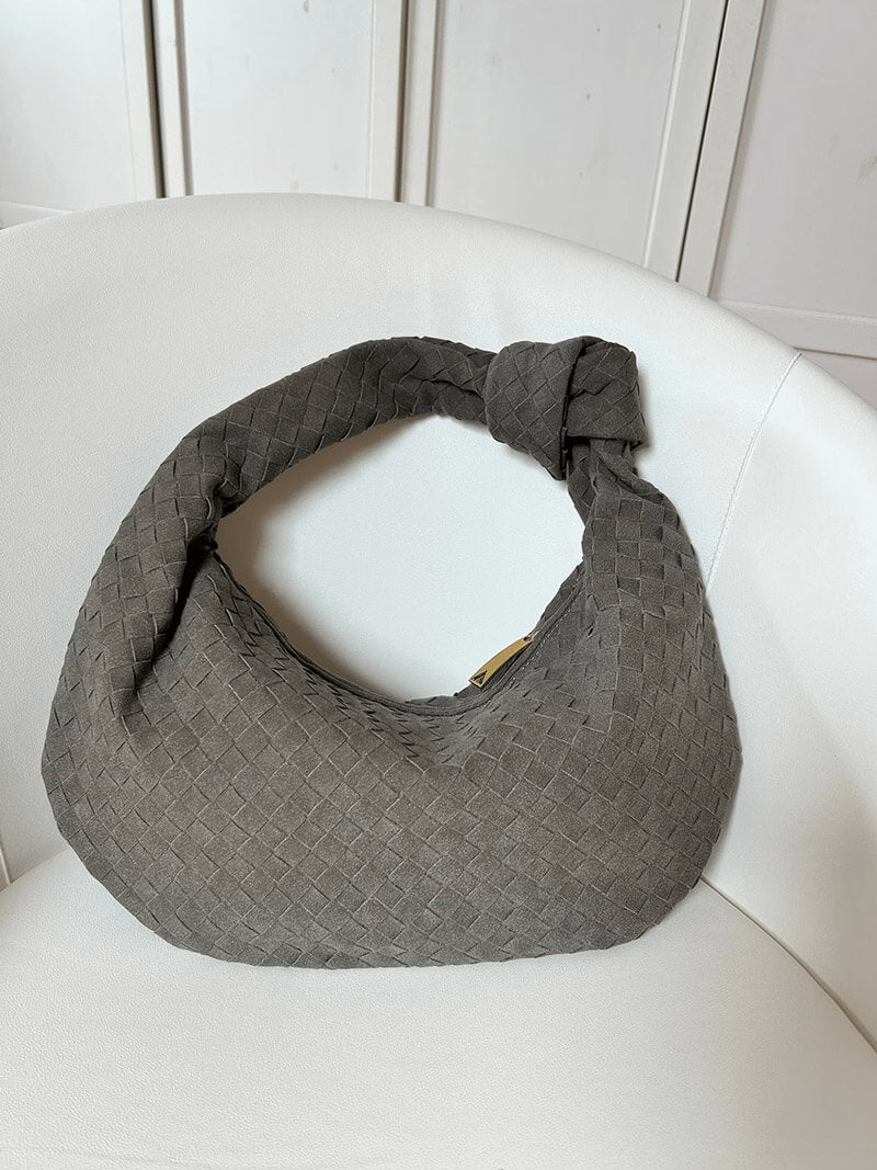 Woven bag worn casually on model's shoulder