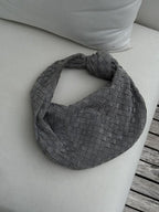 Woman wearing woven bag dressed for evening