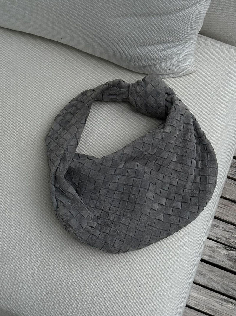 Woman wearing woven bag dressed for evening