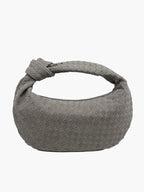 Woven shoulder bag worn crossbody on model, side angle