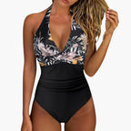 Model wearing striped halter swimsuit standing on beach