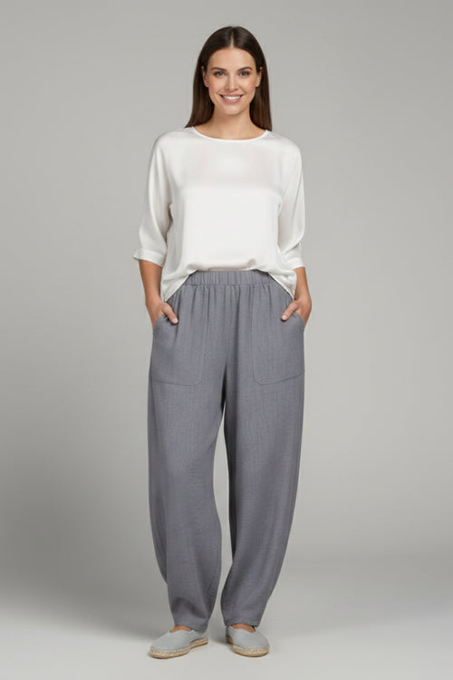 Model wearing grey joggers in standing pose, full length