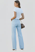 Close-up of distressed rip detailing on light blue denim fabric