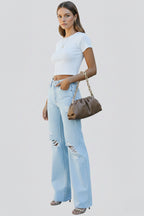 Back view of light blue distressed wide leg jeans on model