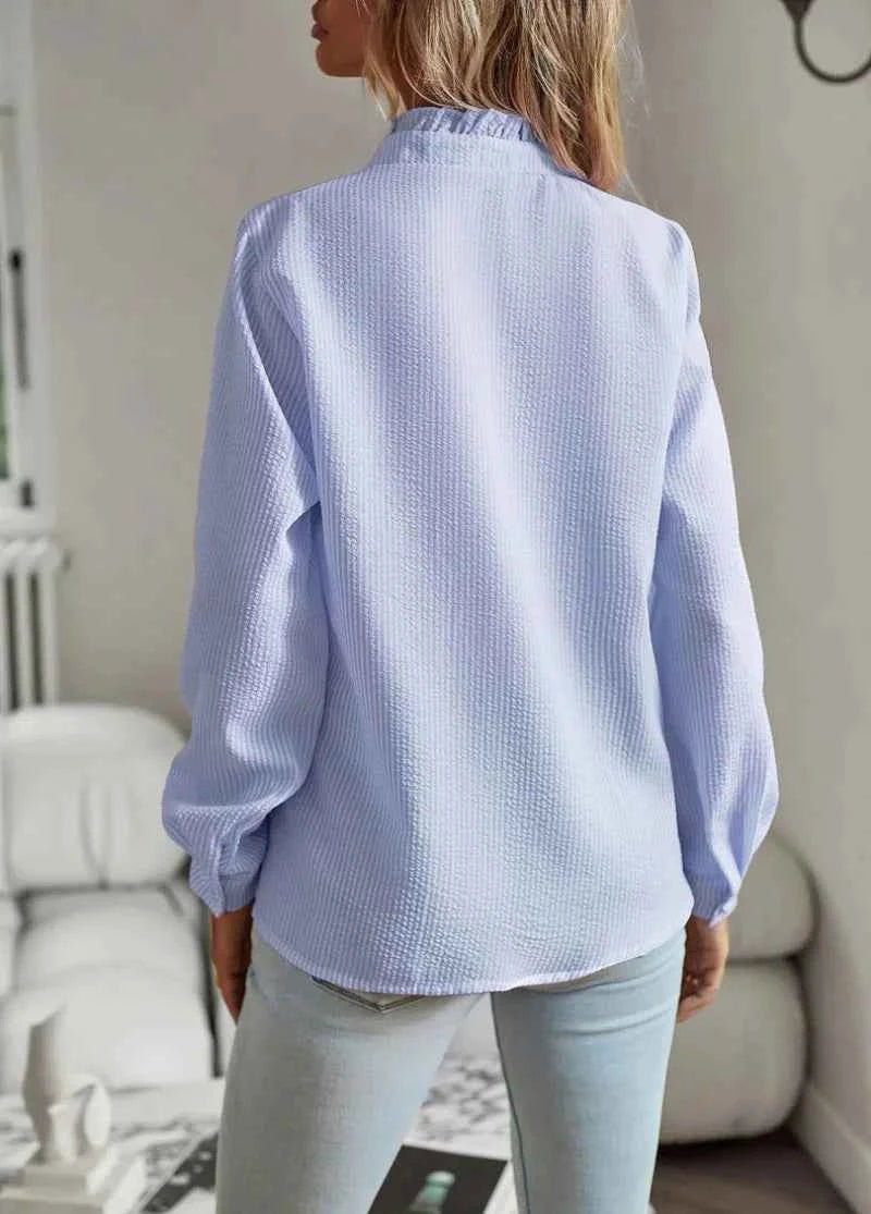 Model wearing blouse tucked into trousers, styled for office