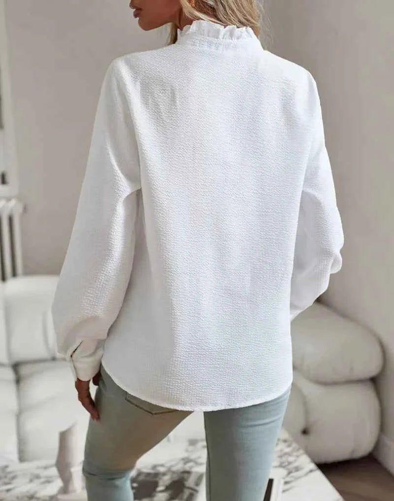 Model in blouse with arms relaxed, casual styling perspective