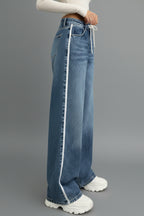 Close-up of drawstring waist detail on medium blue denim jeans