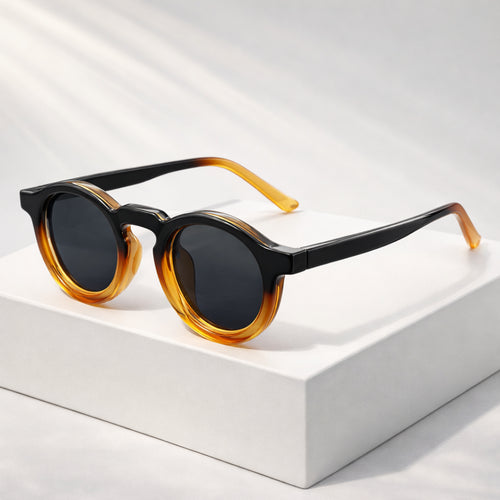 Men's round frame sunglasses with black to amber gradient lenses, front view