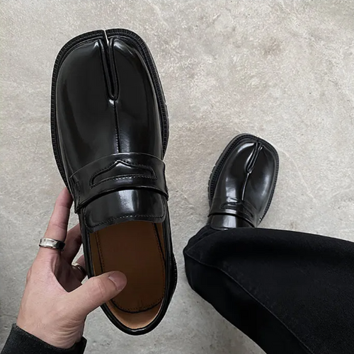 Man wearing black split toe loafers, standing pose showing shoe silhouette