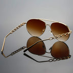 Model in casual outfit wearing chain link aviator sunglasses, overhead angle