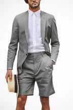 Model wearing grey blazer shorts suit, front-facing pose