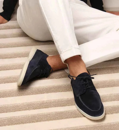Navy suede lace-up loafer displayed on neutral background, side view