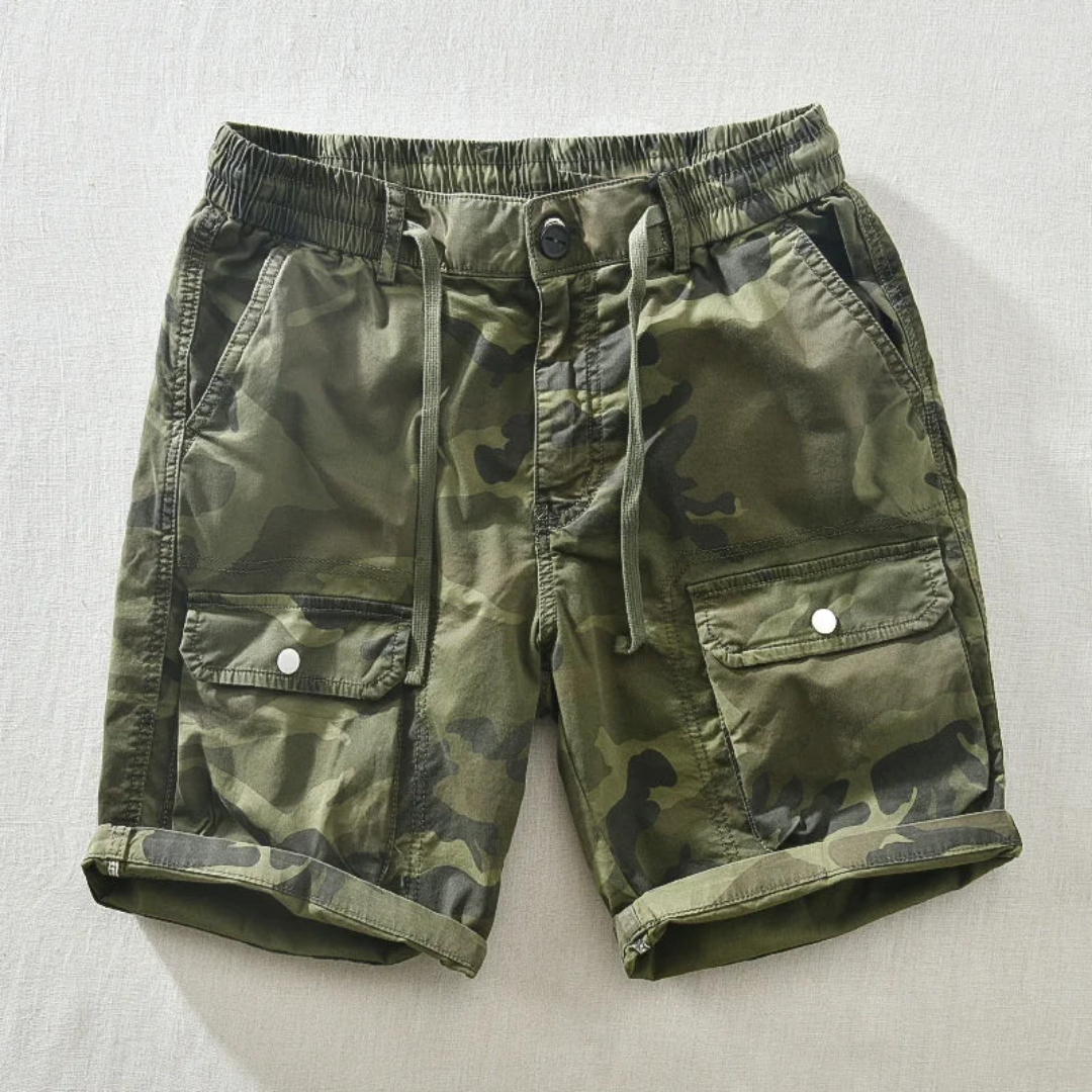 Model wearing camo cargo shorts, standing pose showing fit