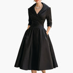 Model in navy wrap dress demonstrating pocket placement and fit