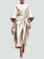Three-quarter angle of model in satin maxi dress, showing movement and drape