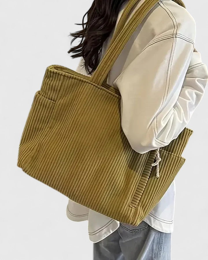 Close-up of soft ribbed corduroy fabric texture in olive tone
