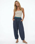 Side detail of peach linen tapered trousers showing pocket opening