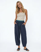 Full-body view of model in peach linen trousers with neutral styling