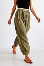 Close-up of drawstring adjustment on peach linen trousers waist