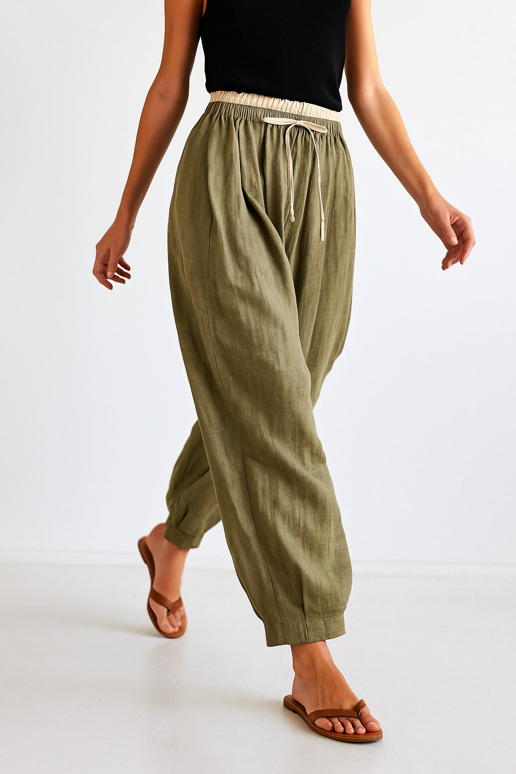 Close-up of drawstring adjustment on peach linen trousers waist