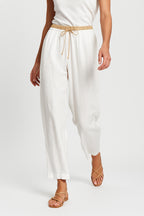 Back pocket area detail on peach linen tapered trousers