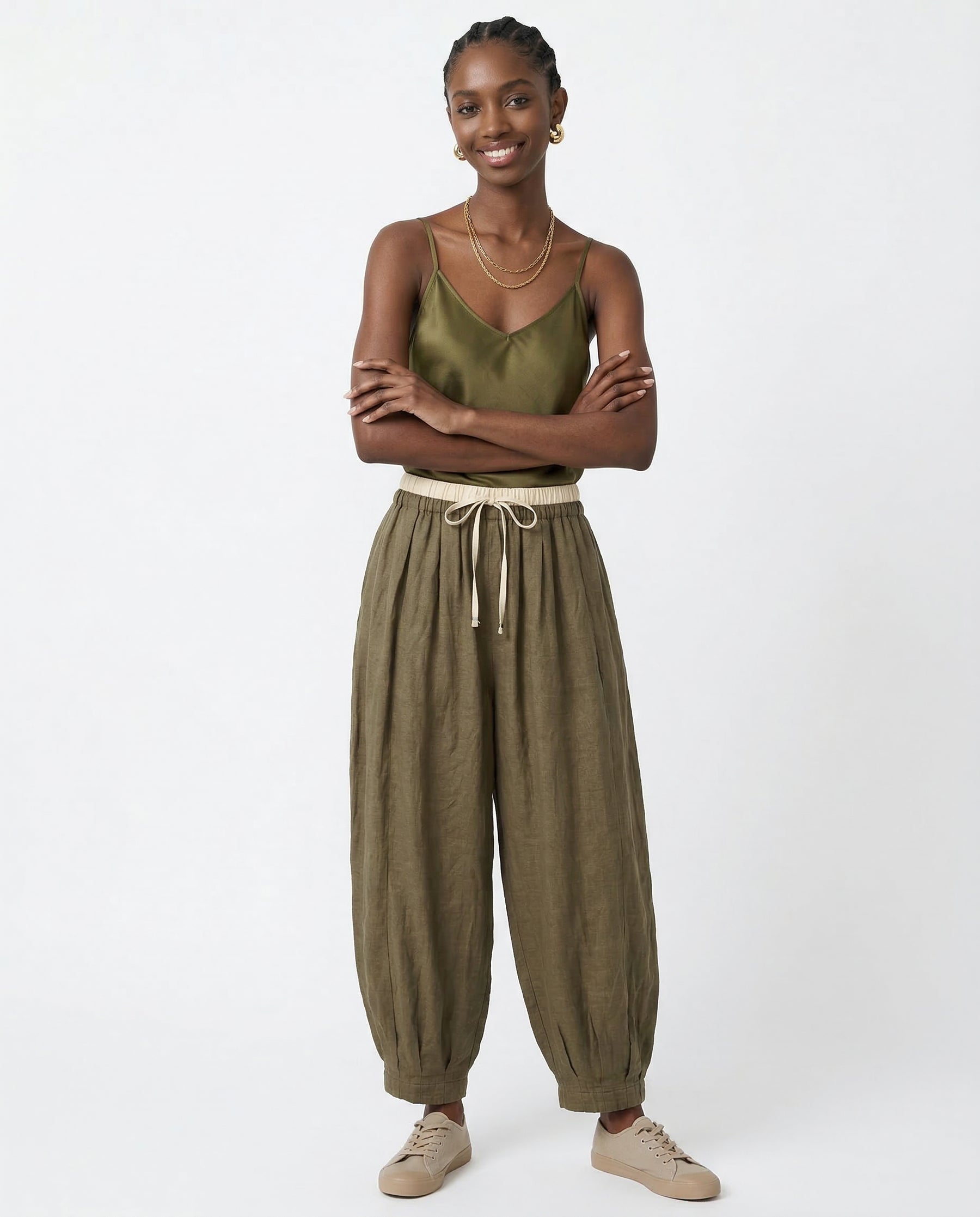 Full-length view of peach linen trousers laid flat on white background