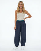 Model in relaxed standing pose wearing peach linen drawstring trousers