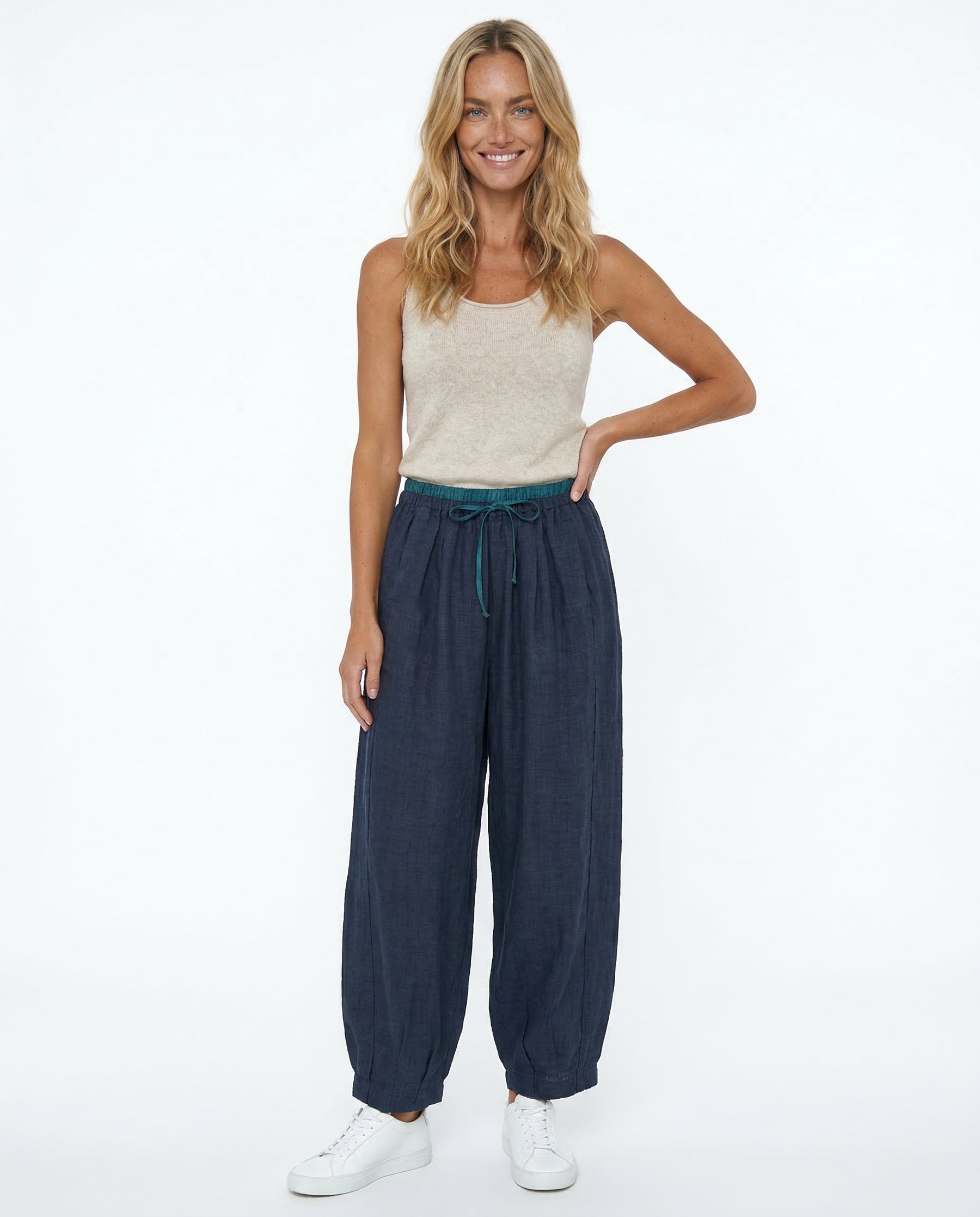 Model in relaxed standing pose wearing peach linen drawstring trousers