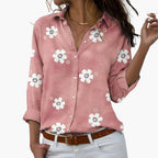 Women's pink floral button-up shirt with white daisy print, displayed flat lay