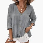 Model wearing sage green blouse, front view showing V-neck and button closure