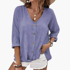 Model wearing blouse styled with neutral trousers, full-length view