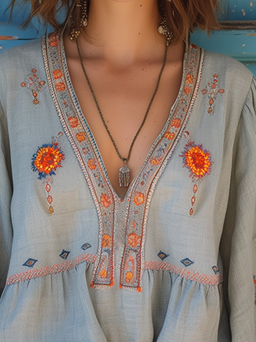 Model wearing embroidered blouse with gathered waist, full-length pose
