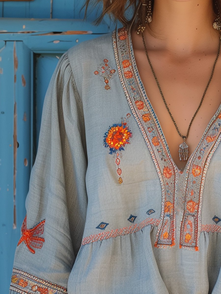 Close-up detail of coral and blue floral embroidery on blouse bodice