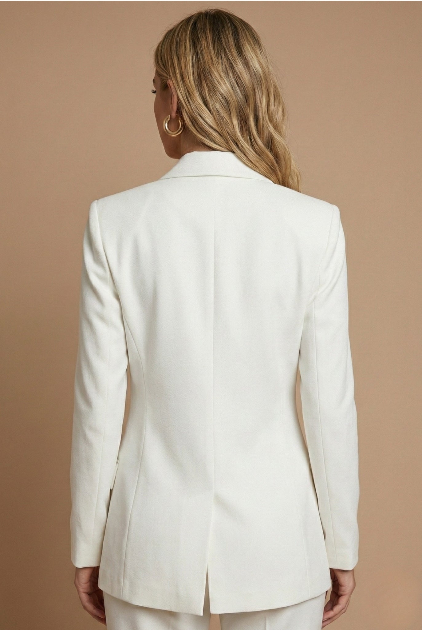 Model wearing tailored blazer set, standing pose from the side