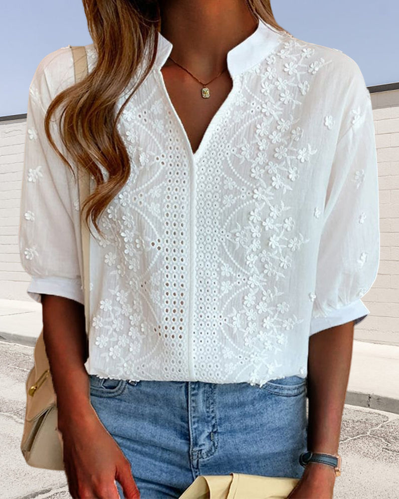 Model wearing white embroidered blouse, standing pose