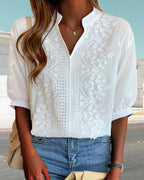 Model in white embroidered blouse, three-quarter pose