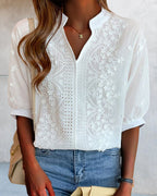 Back view of white V-neck blouse with embroidered panels