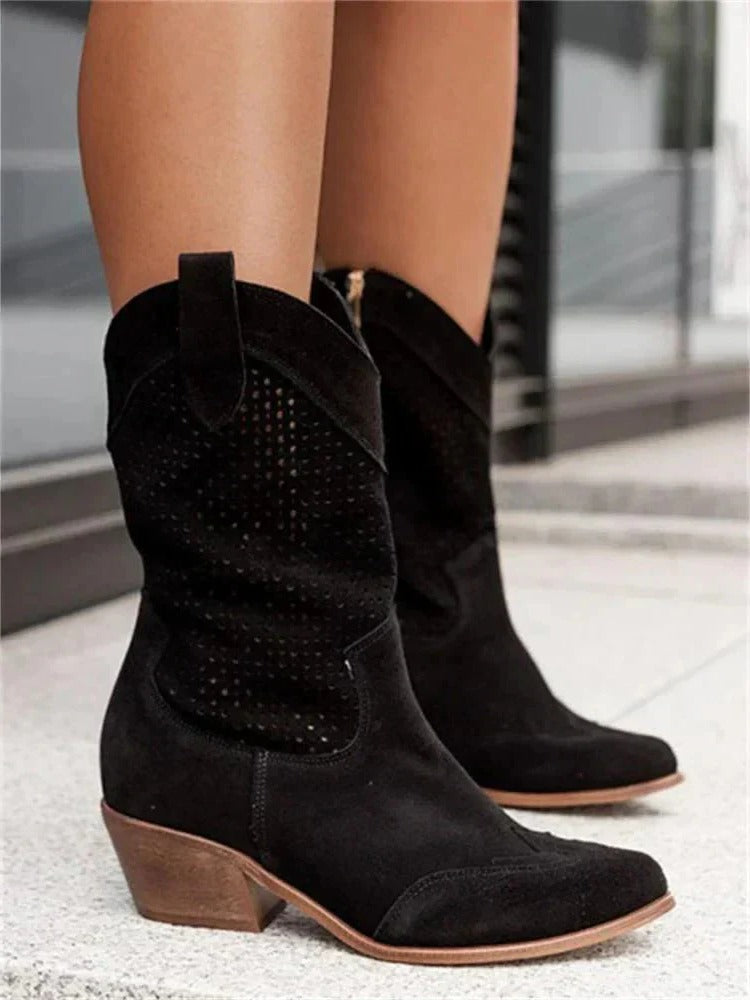 Model wearing perforated cowboy boots, full-length standing pose
