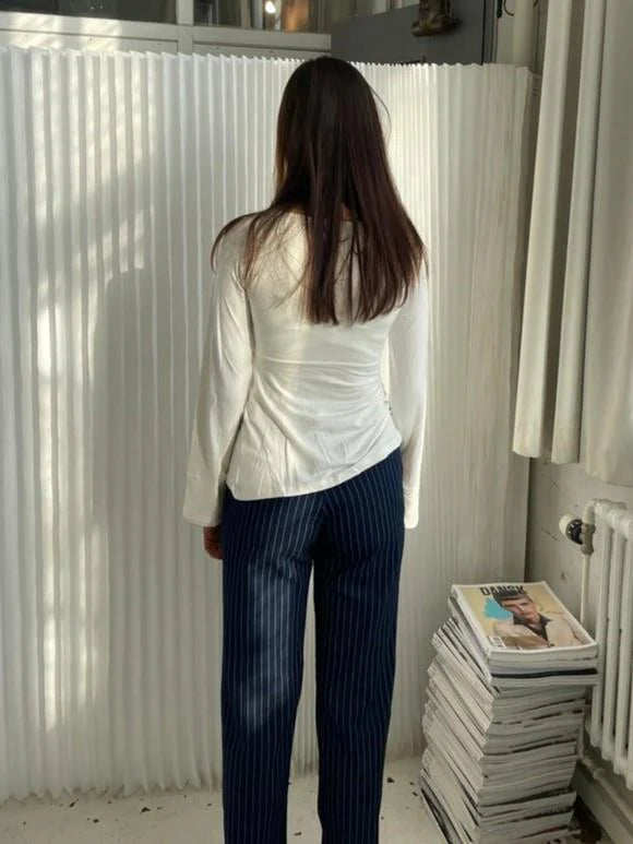 Side view showing fitted waist and long sleeve