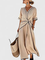 Women's maxi dress with v-neckline, contrast trim, and twisted front detail
